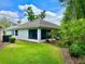 Back of house featuring a screened-in porch, neutral stucco, lawn, and landscaping at 2776 Golf Lake Dr # 1, Plant City, FL 33566