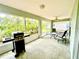 Relaxing screened porch featuring lush garden views, grill, and ceiling fan at 2776 Golf Lake Dr # 1, Plant City, FL 33566