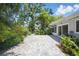 Paved backyard with tropical landscaping offers a relaxing outdoor space at 301 62Nd S Ave, St Petersburg, FL 33705