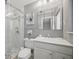 Bathroom featuring a glass door shower with marble tile and a single sink vanity and large mirror at 301 62Nd S Ave, St Petersburg, FL 33705