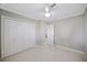 Bright bedroom features terrazzo floors, ceiling fan, and spacious closet at 301 62Nd S Ave, St Petersburg, FL 33705