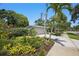 Beautifully landscaped front yard with palm trees and lush greenery enhances this home's curb appeal at 301 62Nd S Ave, St Petersburg, FL 33705