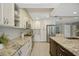 Spacious kitchen featuring white cabinets, stainless steel appliances, granite counters and modern lighting at 301 62Nd S Ave, St Petersburg, FL 33705