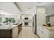 Open kitchen featuring white cabinets, granite countertops, stainless steel appliances, and a center island with seating at 301 62Nd S Ave, St Petersburg, FL 33705