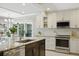 Well-lit kitchen with white cabinetry, stainless steel appliances and granite countertops for a sleek design at 301 62Nd S Ave, St Petersburg, FL 33705