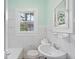 Bright bathroom with mint walls and all white finishes with a view out of the window at 3100 11Th N Ave, St Petersburg, FL 33713
