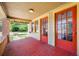 A detailed view of the front porch with red-painted floors and twin red entry doors at 3100 11Th N Ave, St Petersburg, FL 33713