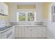 Bright kitchen featuring white cabinetry, subway tile backsplash, and view to exterior at 3100 11Th N Ave, St Petersburg, FL 33713