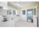 Bright kitchen with white cabinets, white tile floor, and yellow walls at 3100 11Th N Ave, St Petersburg, FL 33713