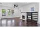 The bright living room features original hardwood floors, fireplace, ceiling fan and many windows at 3100 11Th N Ave, St Petersburg, FL 33713