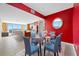 Bright dining area features a glass table, seating for six, and vibrant red accent wall at 331 Cleveland St # 1202, Clearwater, FL 33755