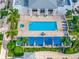 Aerial view of a sparkling outdoor pool, jacuzzi, and lounging area surrounded by lush landscaping and palm trees at 331 Cleveland St # 1202, Clearwater, FL 33755