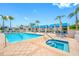 Inviting outdoor pool area with comfortable lounge chairs, umbrellas, and clear blue water, surrounded by palms at 331 Cleveland St # 1202, Clearwater, FL 33755