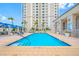 Relaxing outdoor pool with shallow steps, complemented by stylish seating and shade structures near high-rise building at 331 Cleveland St # 1202, Clearwater, FL 33755