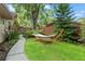 A peaceful backyard featuring a cozy hammock amidst lush greenery and a well-maintained lawn at 3320 Pattie Pl, Palm Harbor, FL 34685