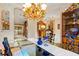 Elegant dining room with a modern chandelier, a glass table, and access to other living spaces at 3320 Pattie Pl, Palm Harbor, FL 34685