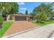 Charming single-story home with mature landscaping, brick driveway, and inviting curb appeal on a sunny day at 3320 Pattie Pl, Palm Harbor, FL 34685