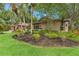 A beautifully landscaped front yard features mature palms and lush plantings surrounding the charming single-story home at 3320 Pattie Pl, Palm Harbor, FL 34685