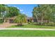 Charming single-story home with mature landscaping, brick driveway, and inviting curb appeal on a sunny day at 3320 Pattie Pl, Palm Harbor, FL 34685