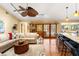 Inviting living room with hardwood floors, a ceiling fan, and access to the outside through glass doors at 3320 Pattie Pl, Palm Harbor, FL 34685