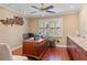 Inviting home office with a wooden desk, shuttered windows, and warm wood-look flooring at 3320 Pattie Pl, Palm Harbor, FL 34685