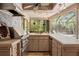 Outdoor kitchen with stainless steel grill, ample counter space, and views of the pool area at 3320 Pattie Pl, Palm Harbor, FL 34685