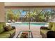 Covered screened patio with seating overlooking a sparkling pool and lush, tropical backyard at 3320 Pattie Pl, Palm Harbor, FL 34685