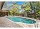 Beautiful, screened pool with an extended lanai, mature trees, and lush landscaping for ultimate privacy at 3320 Pattie Pl, Palm Harbor, FL 34685