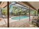 Relaxing screened-in pool featuring a brick deck and lush landscaping for ultimate privacy at 3320 Pattie Pl, Palm Harbor, FL 34685