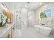 Bright bathroom with marble accents, double showers, a soaking tub, and modern fixtures at 4166 38Th S St, St Petersburg, FL 33711