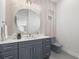 Gray-themed powder room with round mirror and patterned wallpaper at 4166 38Th S St, St Petersburg, FL 33711