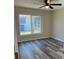 Well-lit bedroom with hardwood flooring, ceiling fan, and large window overlooking the backyard at 4212 Pasadena Cir, Sarasota, FL 34233