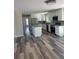 Open-concept kitchen with stainless steel appliances, white cabinets, and luxury vinyl plank flooring at 4212 Pasadena Cir, Sarasota, FL 34233