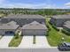 An aerial view shows the home's attached two-car garage, lovely landscaping, and a screened lanai at 4639 Bexley Village Dr, Land O Lakes, FL 34638