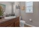 Charming half bathroom with a wood vanity, neutral paint, decorative wall art, and a bright window at 4639 Bexley Village Dr, Land O Lakes, FL 34638