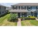 Inviting townhome featuring a covered porch, manicured lawn, and brick walkway at 4639 Bexley Village Dr, Land O Lakes, FL 34638
