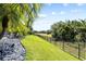 This image displays the lush green lawn of a landscaped backyard, with a secured fence line at 5313 Sanderling Ridge Dr, Lithia, FL 33547