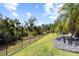 This image displays the lush green lawn of a landscaped backyard, with a secured fence line at 5313 Sanderling Ridge Dr, Lithia, FL 33547