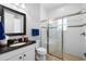 Clean bathroom featuring granite vanity, framed mirror, tile floor, and glass enclosed shower at 5313 Sanderling Ridge Dr, Lithia, FL 33547