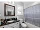 A bathroom features a granite sink vanity, mirror, toilet, and shower-tub combo with neutral decor at 5313 Sanderling Ridge Dr, Lithia, FL 33547