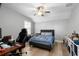 A simple bedroom featuring a bed, desk, and shelving with hardwood floors and natural lighting at 5313 Sanderling Ridge Dr, Lithia, FL 33547
