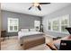 Cozy bedroom with natural light, hardwood floors, and a comfortable bed with neutral bedding at 5313 Sanderling Ridge Dr, Lithia, FL 33547
