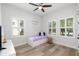 Sunlit bedroom with modern wood floors, white trim, and plantation shutters at 5313 Sanderling Ridge Dr, Lithia, FL 33547