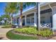 Exterior view of the community clubhouse with classic white columns, lush landscaping and a welcoming patio area at 5313 Sanderling Ridge Dr, Lithia, FL 33547