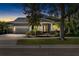 Twilight view of a modern home showcasing a three-car garage, manicured lawn, and inviting front porch at 5313 Sanderling Ridge Dr, Lithia, FL 33547