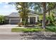 Charming home featuring a well-manicured lawn, two-car garage, and inviting front porch with classic architectural details at 5313 Sanderling Ridge Dr, Lithia, FL 33547