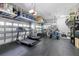 A well-equipped garage features a treadmill, bikes, and overhead storage racks for organization at 5313 Sanderling Ridge Dr, Lithia, FL 33547