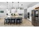 Stylish kitchen featuring white cabinets, a gray island with granite countertops, and stainless steel appliances at 5313 Sanderling Ridge Dr, Lithia, FL 33547