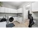 The laundry room features modern washer and dryer units, ample cabinet space, and tile flooring at 5313 Sanderling Ridge Dr, Lithia, FL 33547