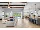 Open-concept living space with tile floors, ceiling beams, and access to the outdoor pool area at 5313 Sanderling Ridge Dr, Lithia, FL 33547